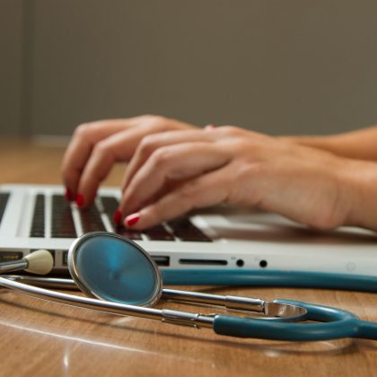 A medical doctor does research on a laptop