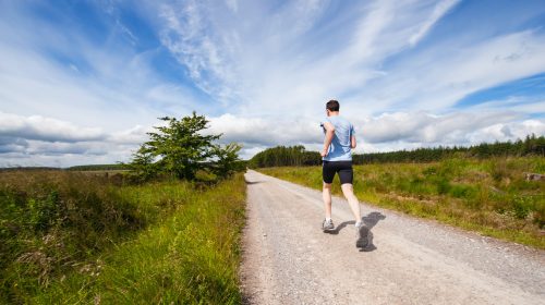 A runner jogs down a country road