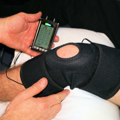 A physical therapist administers steroid iontophoresis onto a patient's inflamed knee